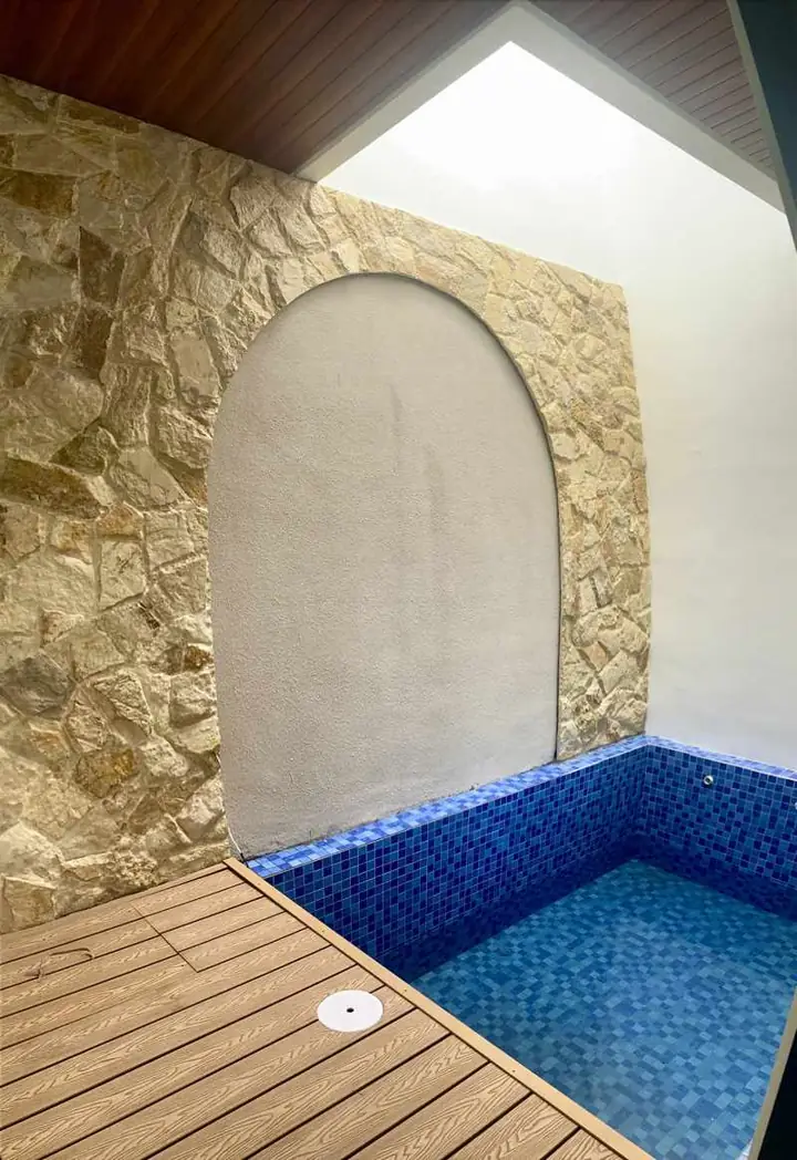 Private pool dengan dinding batu dan dek di dalam villa